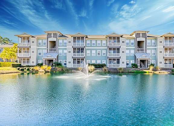 A large apartment complex with a fountain in front.