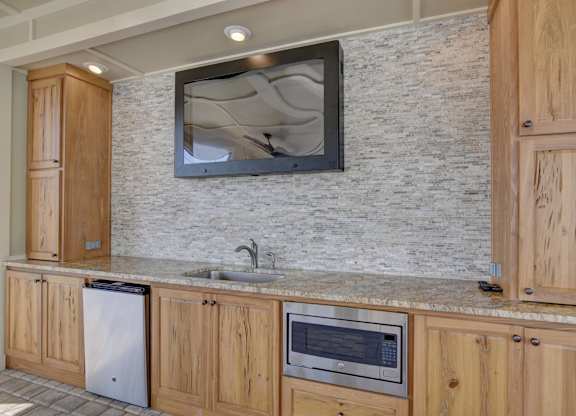 A kitchen with wooden cabinets and a granite countertop.
