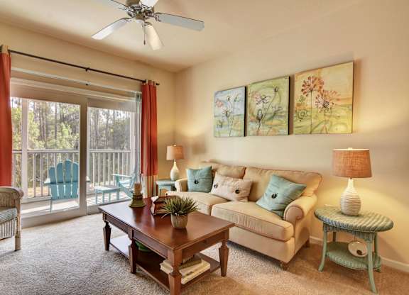 A living room with a couch, chair, and sliding glass doors.