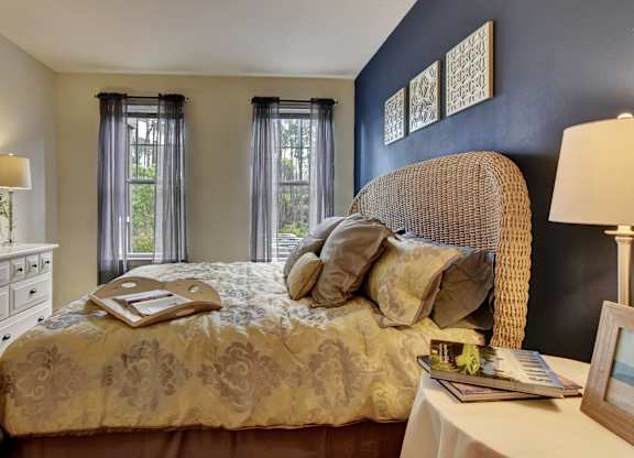 A bedroom with a bed, nightstand, and window.