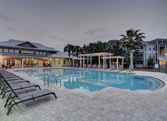 A large outdoor swimming pool surrounded by lounge chairs.