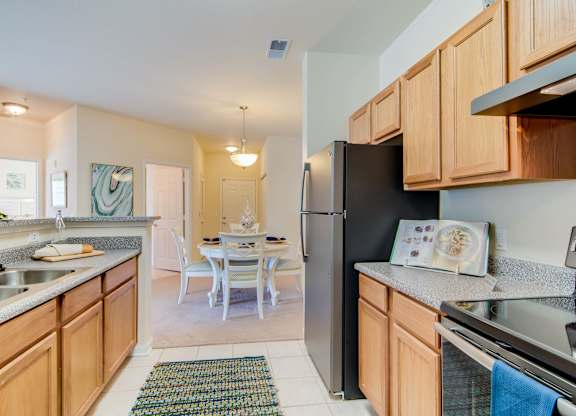 A kitchen with wooden cabinets and a black refrigerator.