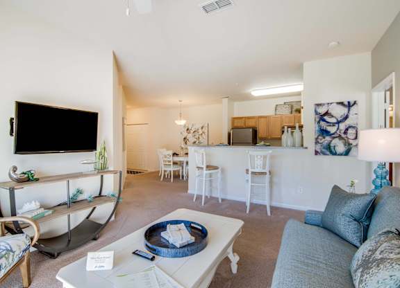 A living room with a couch, chairs, and a television.