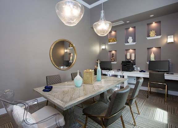 A dining room with a round mirror and a table with chairs.