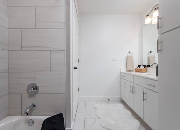 En-suite bathroom with double vanity, premium fixtures, and tile tub/shower surround at 2020 Providence in Huntsville, AL