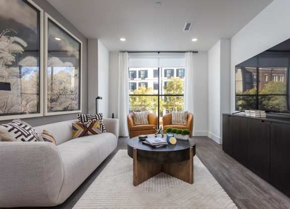 Modern living room with oversized windows, plank flooring, and premium lighting at 2020 Providence in Huntsville, AL