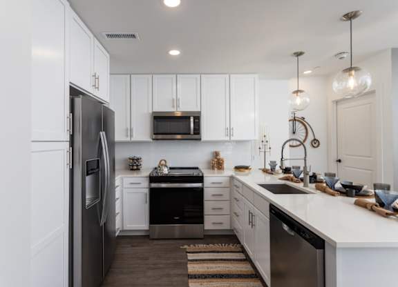 A modern kitchen with white cabinets and stainless-appliances at 2020 Providence in Huntsville, AL