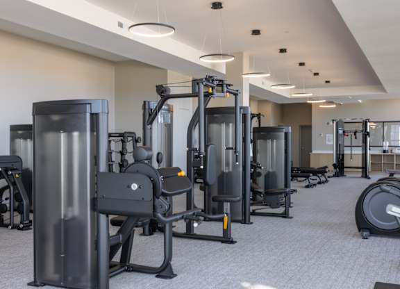 A gym with a variety of equipment including treadmills, weights, and exercise machines at 2020 Providence in Huntsville, AL.