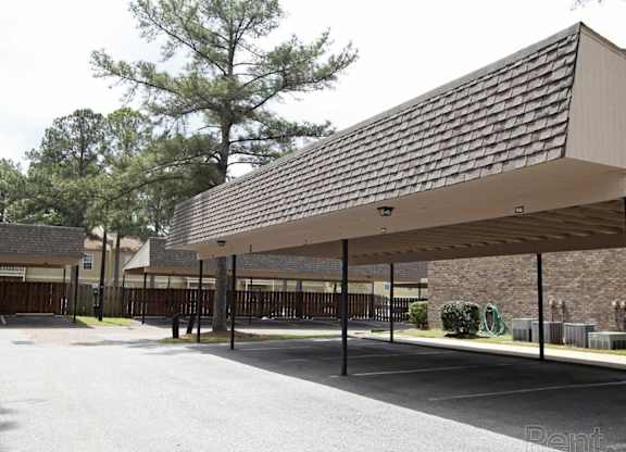 A parking lot with a long covered parking area The Oakley at Hillcrest in Mobile, AL.