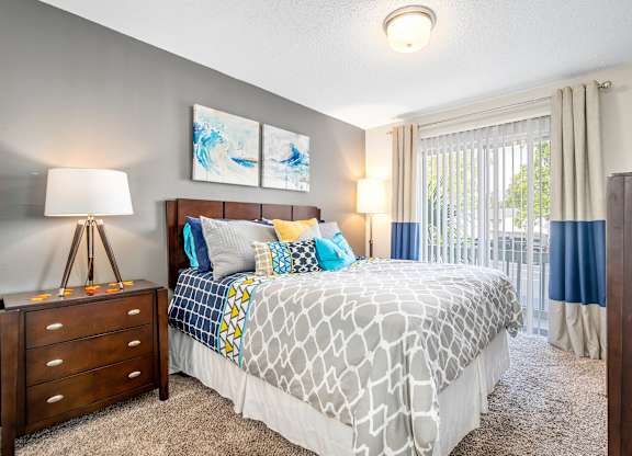 spacious primary bedroom with direct access to private patio or balcony at 701 South Apartments in Mobile, AL