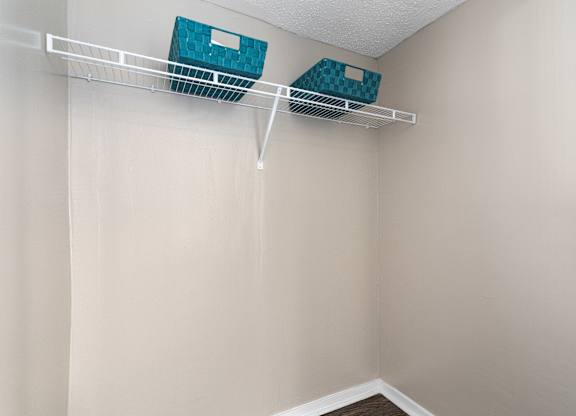 Two blue boxes are hanging on a white shelf.
