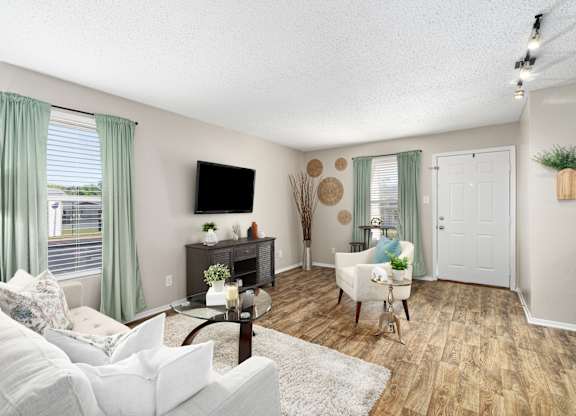 A living room with a white sofa and a wooden floor.