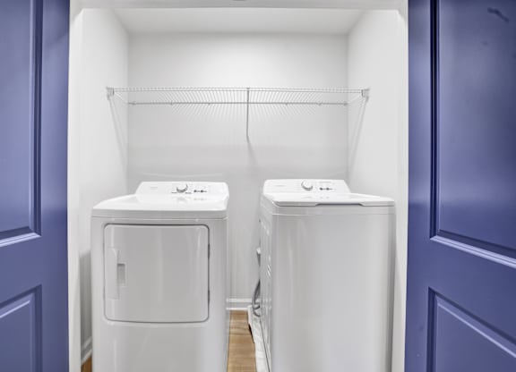 two washing machines in a room with a blue door