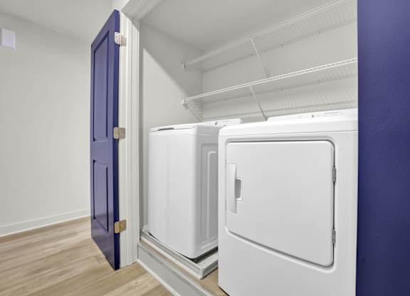 three refrigerators in a room with a blue door
