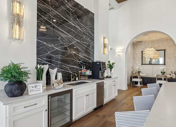 A kitchen with a white counter top and a black vase.