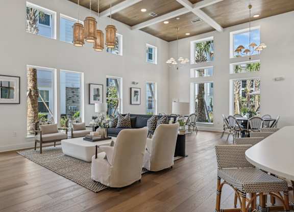 A living room with a white couch and chairs.