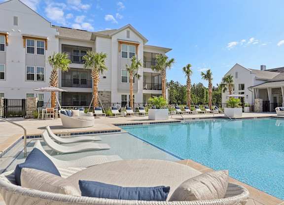 A large white building with a pool in front.