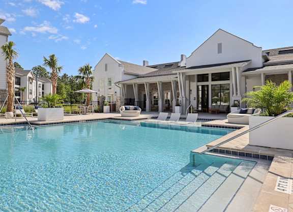 A large swimming pool in front of a white building.