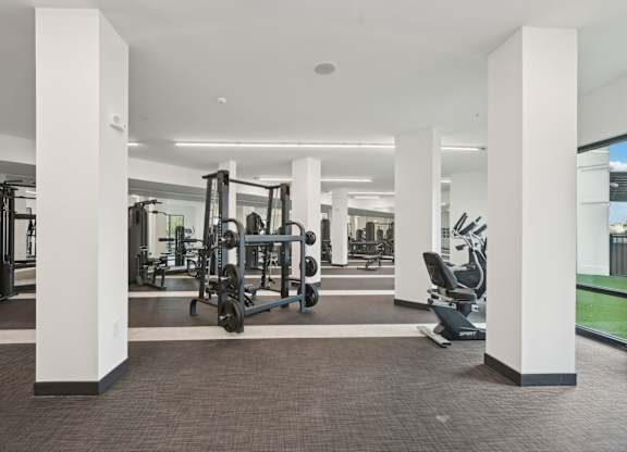 A gym with weights and cardio machines at Tapestry University Park in Sarasota, FL