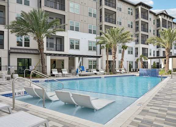 Swimming pool with tanning shelf at Tapestry University Park Apartments in Sarasota, FL