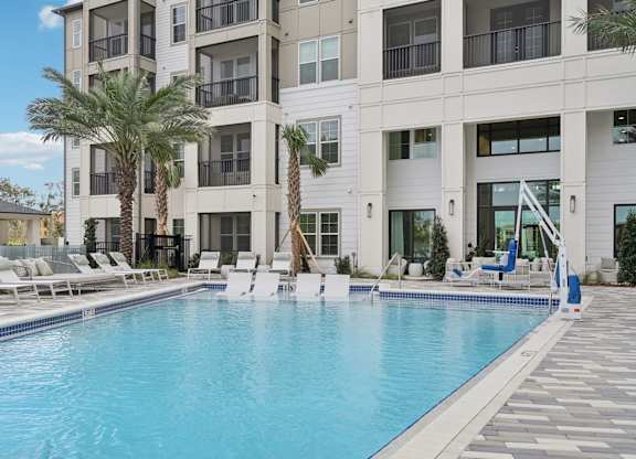 a large pool with sundeck, chaise lounges at Tapestry University Park Apartments in Sarasota, FL