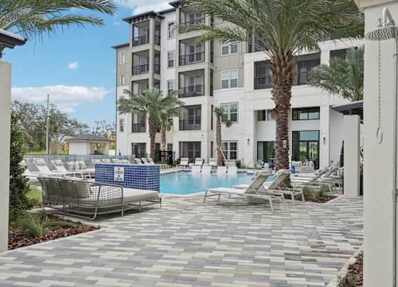 outdoor shower and swimming pool area with sundeck at Tapestry University Park Apartments in Sarasota, FL