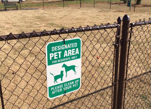A sign on a fence designates the area as a pet-only zone.