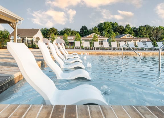 a pool with sun shelf and chaise loungers at Anthem Luxury Rentals and Apartment Homes in Huntsville, AL