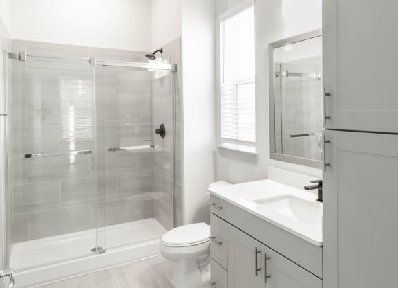 a bathroom with tile floors and shower surrounds at Anthem Apartments and Cottages in Huntsville, Alabama
