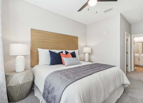 a bedroom with a large bed and a ceiling fan