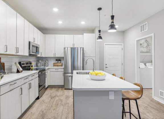 a large kitchen with white cabinets and stainless steel appliances
