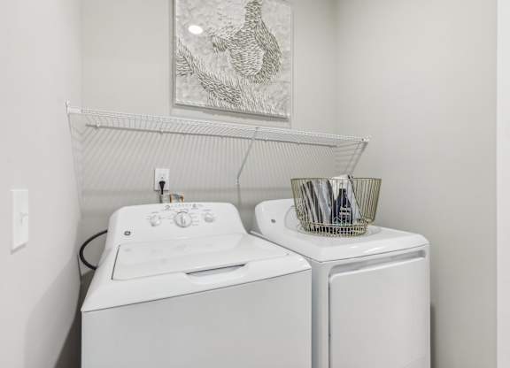 a white washer and dryer in a white laundry room