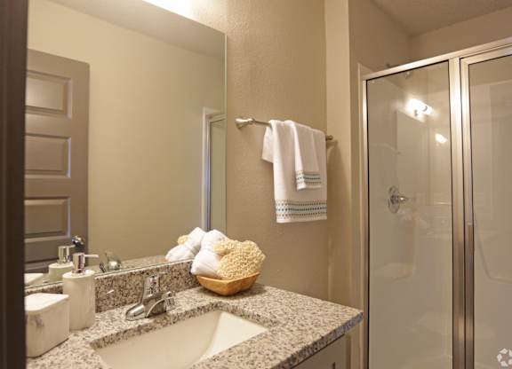 Bathroom with stand-alone shower and granite countertops at Avia Apartments in Vestavia Hills, AL