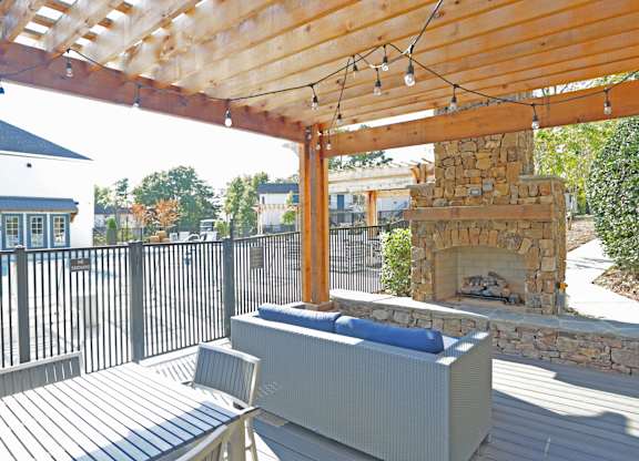 A wooden deck with a bench and a fireplace at Avia Apartments in Vestavia Hills, AL