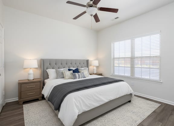 A bedroom with a large bed and a ceiling fan.