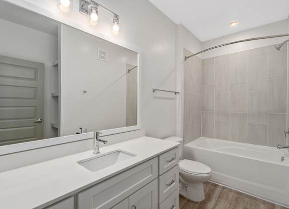 A white bathroom with a sink, toilet, and bathtub.