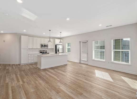 A kitchen with wooden floors and white walls.