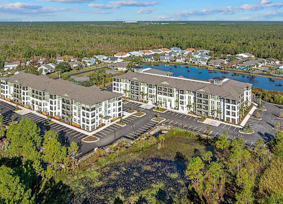 A large building complex with a parking lot in front of it.