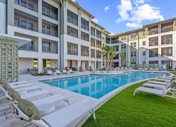 A large white building with a pool in front.