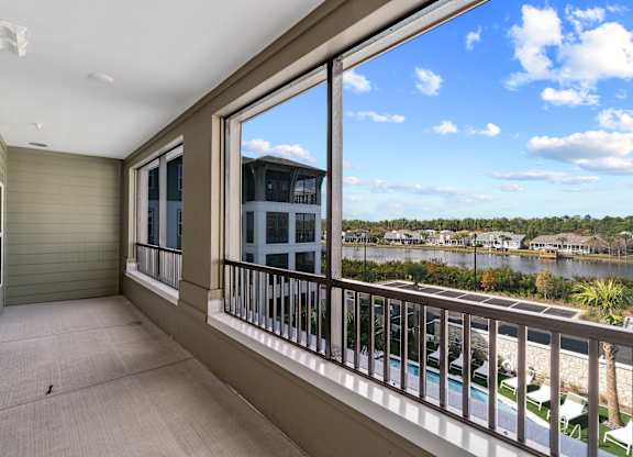 A balcony with a view of a lake and houses.