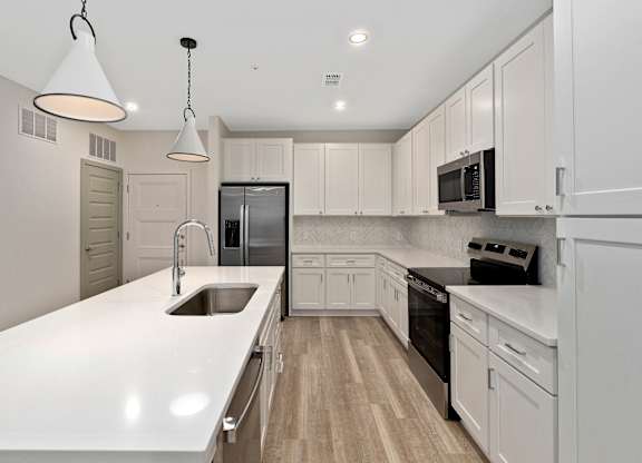 A modern kitchen with white cabinets and appliances.