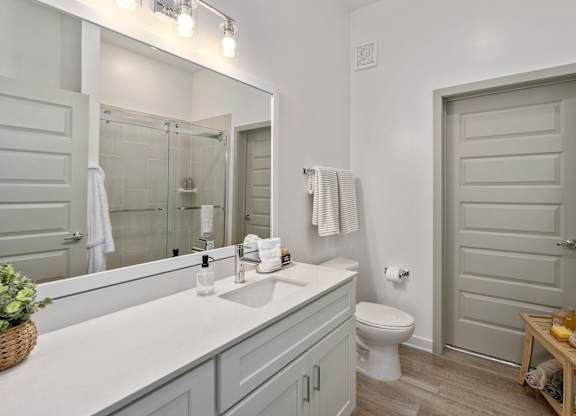 A bathroom with a white sink and a white toilet.