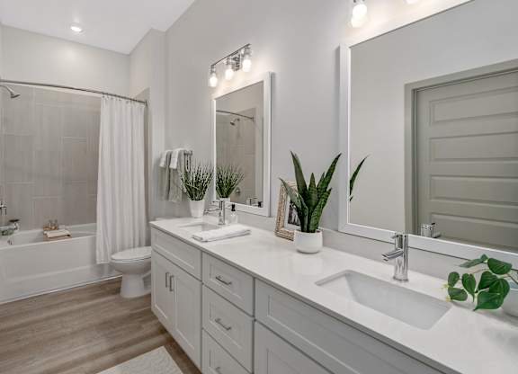 A white bathroom with a white tub and sink.