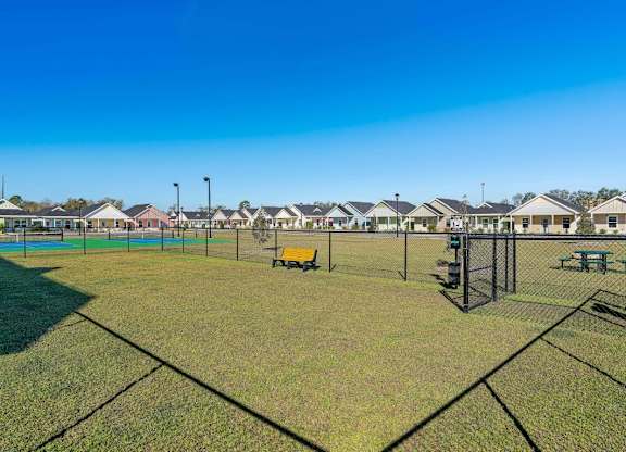 A park with a playground and a fence.