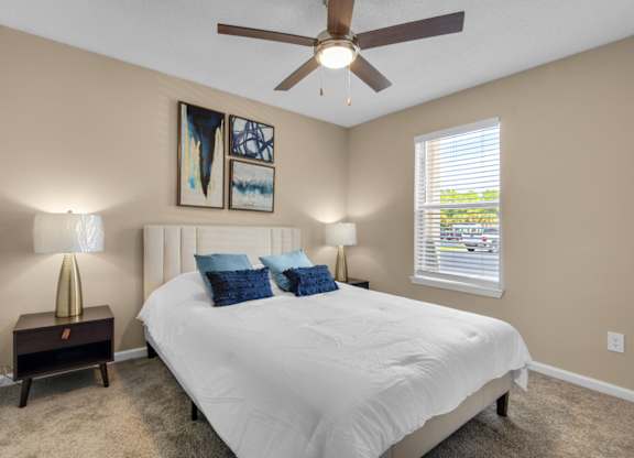 A bedroom with a ceiling fan and large window at Crystal Lake in Pensacola, Florida..