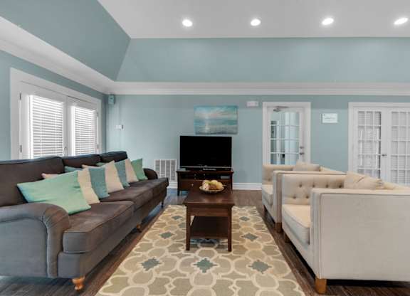 Lounge area in the clubhouse with couches and a TV at Crystal Lake in Pensacola, Florida.