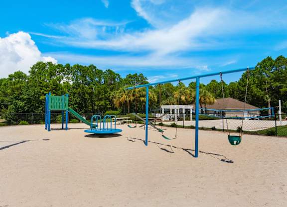 An outdoor playground with swings and a slide at Crystal Lake in Pensacola, Florida.