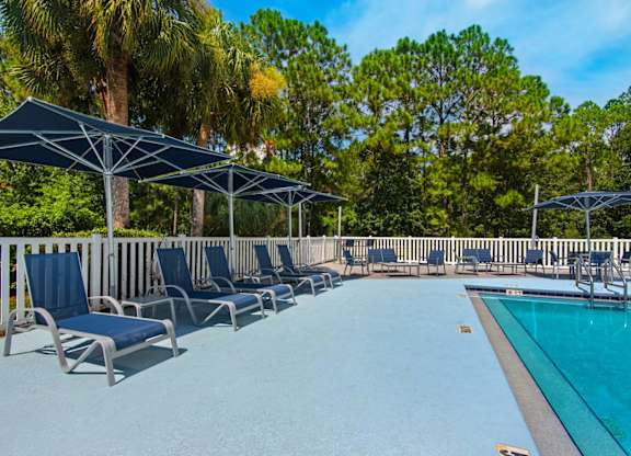 Sun loungers and umbrellas that surround the outdoor pool at Crystal Lake in Pensacola, Florida.