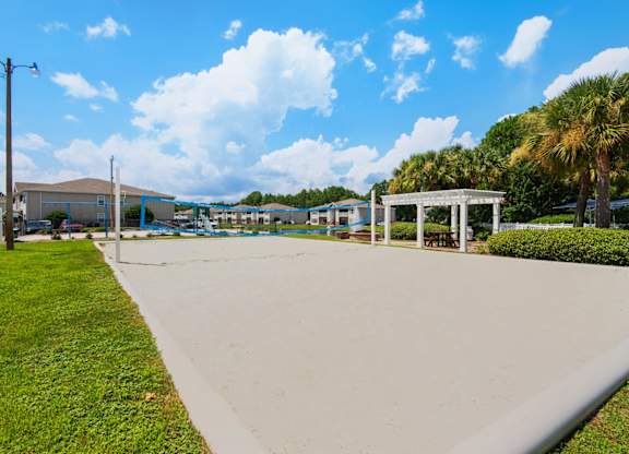 A sand volleyball court with a pavilion on the perimeter at Crystal Lake in Pensacola, Florida.