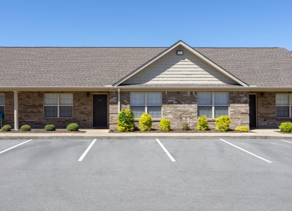 the front of a landscaped building at The Oakley at Deerfield Apartments in Florence, AL